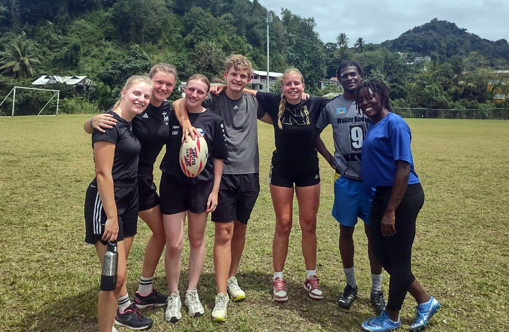 Group of friends posing with rugby ball
