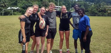 Group of friends posing with rugby ball